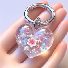 This adorable, heart-shaped resin art keychain sports a pastel palette & sparkling glitter. Tiny embedded flowers peek through its crystal clear finish. The silver ring gives a polished touch. Perfect for adding a dash of magical charm to your everyday life. #ResinArt #Keychain #TeenageFashion #PastelAccessories #GlitterArt #FloralDesign Resin Cute Keychain, Cute Pink Resin Jewelry, Resinart Keychain, Resin Art Pendant, Resin Art Keychain, Pink Resin Keychain, Resin Heart Keychain, Pink Resin Jewelry With Heart Charm, Crystal Keyring