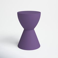 a purple vase sitting on top of a white table