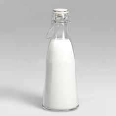 a glass bottle filled with milk sitting on top of a table