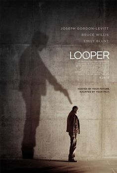 a man standing in front of a wall with the words looper written on it