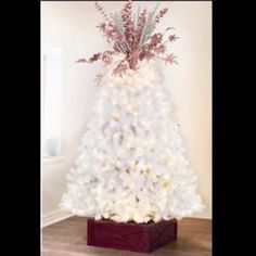 a white christmas tree with flowers in it