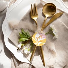 two forks and spoons sitting on top of a white plate next to a napkin