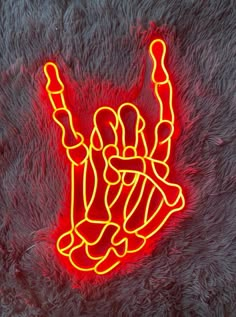 a neon sign that is on top of a furry surface in the shape of a hand