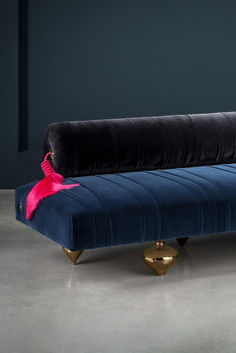 a blue velvet couch with pink tassels on it