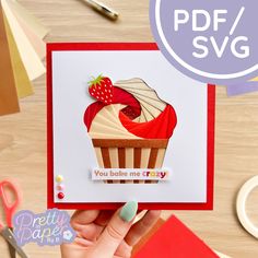 a hand holding up a card with a cupcake on it