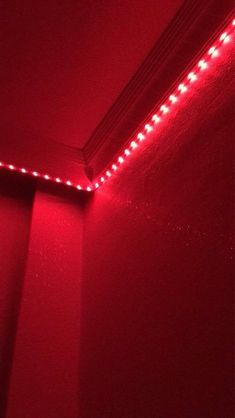 a red light is shining on the wall in a room with no one around it