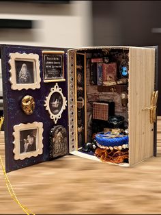 an open book with pictures and other items inside on a wooden table next to a chain