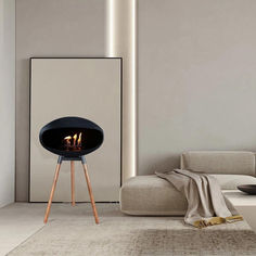 a modern fireplace in the middle of a living room with white walls and flooring