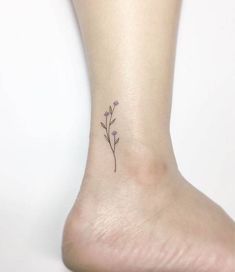 a small flower tattoo on the ankle