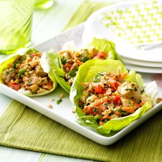 two lettuce cups filled with chicken salad on top of a white platter