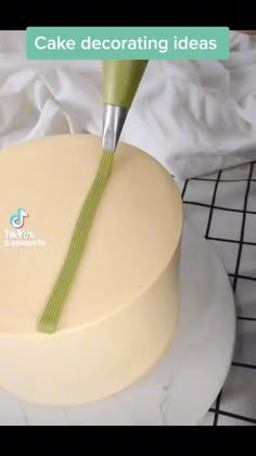 there is a cake decorated with green icing and a knife sticking out of it