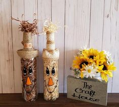 two wine bottles decorated to look like scarecrows with sunflowers in the background