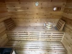 a wooden sauna with two buckets on the floor