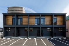 an empty parking lot in front of a two story building with balconies on the second floor