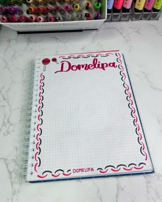 a notebook with the word domula written on it next to some crayons