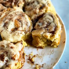 cinnamon rolls on a plate with icing drizzled over them