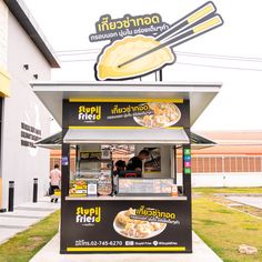 a food stand with noodles and chopsticks on it in front of a building