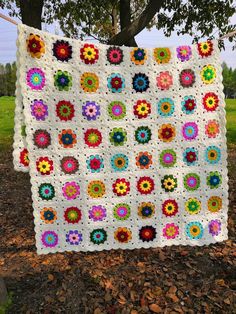 a crocheted blanket hanging from a tree