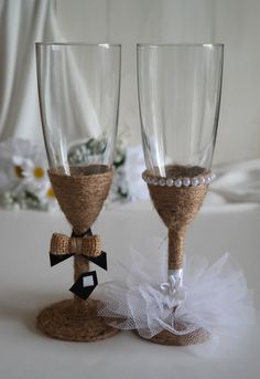 two wine glasses decorated with burlocks and pearls are sitting next to each other