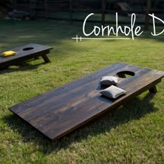 two cornhole boards sitting on top of a green field next to some yellow shoes