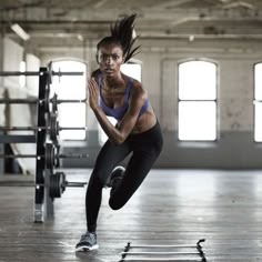 a woman is running in the middle of a gym