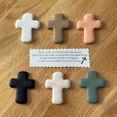 small cross shaped cookies sitting on top of a wooden table next to a paper sign