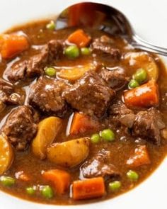 a white bowl filled with beef stew and carrots