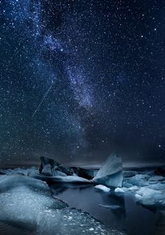 the night sky is filled with stars above icebergs and snow floese