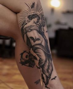 a woman's leg with a tattoo on it and an image of the virgin mary