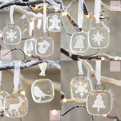 four glass ornaments hanging from a tree with white snowflakes and christmas decorations on them