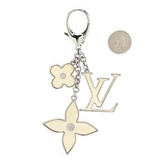 a keychain with two flowers and a coin