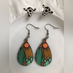 the earrings are decorated with cactus and tortoiseshells in wood, on a white plate