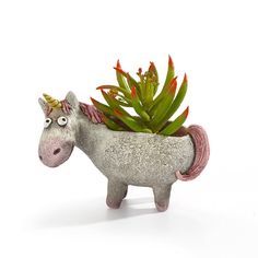 a ceramic unicorn planter with succulents in it