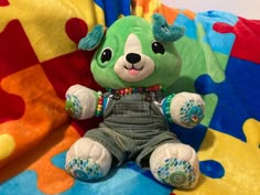 a stuffed animal sitting on top of a colorful blanket