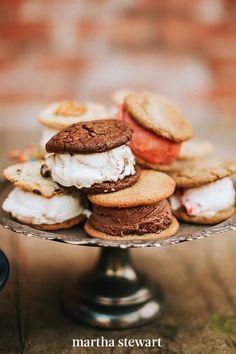 an assortment of cookies and ice cream sandwiches on a cake stand