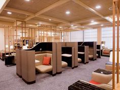 an office lobby with multiple seating areas and wooden partitions