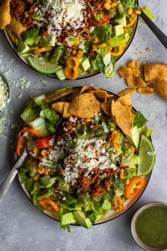 two plates filled with taco salad and tortilla chips