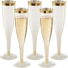 four champagne flutes with gold rims are lined up