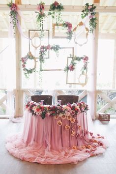 a table with pink cloths and flowers on it is set up for a wedding