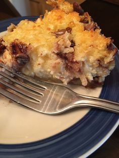 a piece of casserole on a blue and white plate with a silver fork