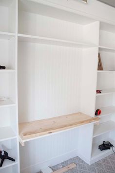 an empty room with shelves and tools on the floor