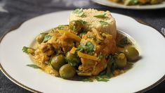 a white plate topped with green olives and bread