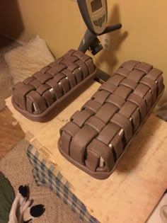 two cakes sitting on top of a wooden table next to a hair dryer and scissors