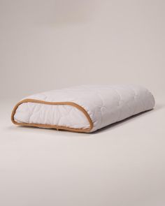 an image of a dog bed that is made out of white fabric and wooden trim