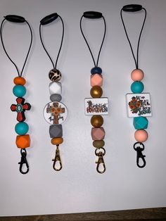 four different colored beads hanging on a wall