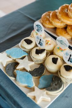 a table topped with lots of cupcakes covered in frosting and decorated like stars