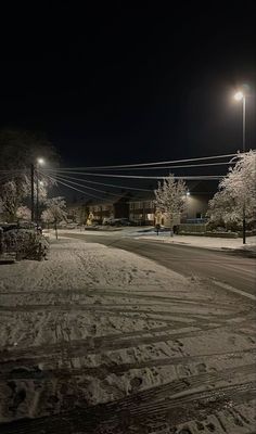 an empty street at night with snow on the ground