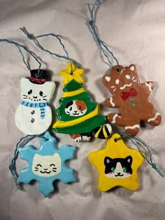 four ceramic ornaments are hanging on a string