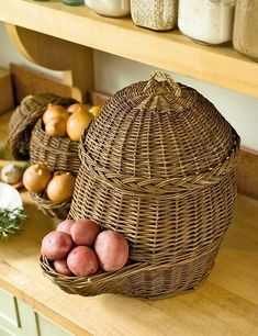 some potatoes are sitting in a basket on a counter next to other vegetables and jars