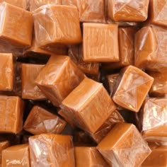 a pile of chocolate cubes sitting on top of each other in plastic wrappers